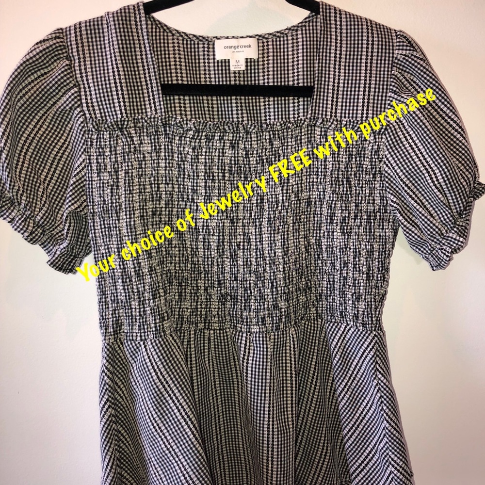 Black and white gingham smocked short sleeve op with a peplum